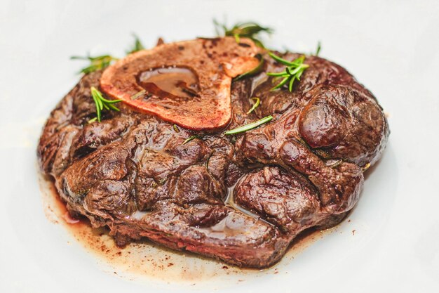 Bistec de ternera estofado cocido en el hueso osobuco con pimienta romero en el tablero