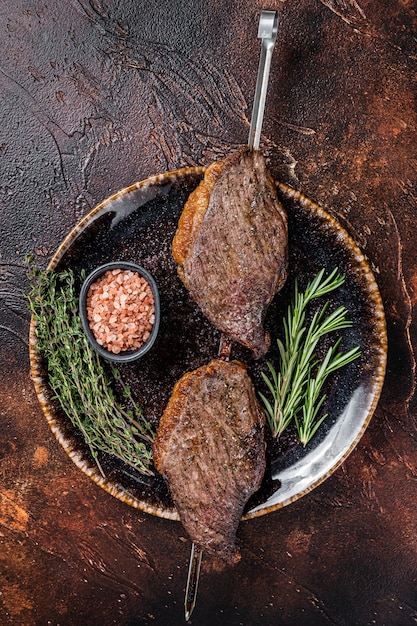 Bistec de ternera picanha añejado en seco a la parrilla brasileño con hierbas Fondo oscuro Vista superior