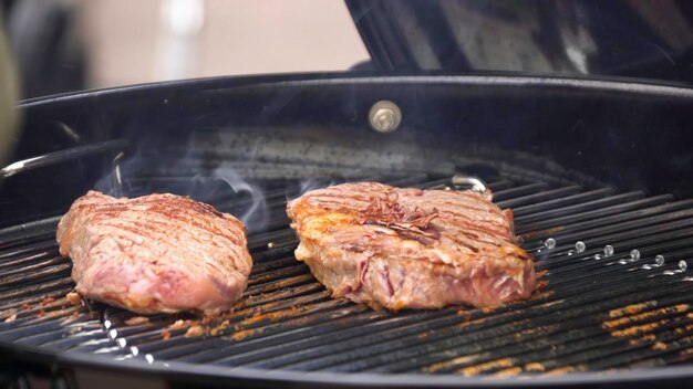 bistecs de carne en la parrilla con llamas cocinar bistecs en los carbones concepto de comer carne