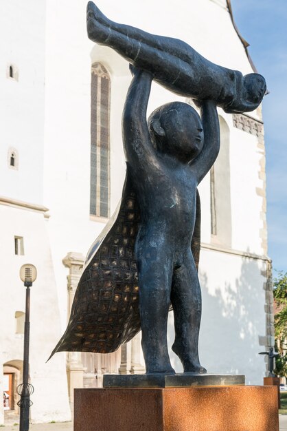 BISTRITA, TRANSYLVANIA / ROMANIA - SETEMBRO 17: Escultura moderna em frente à Igreja Luterana na Bistrita Transylvania / Romênia em 17 de setembro de 2018