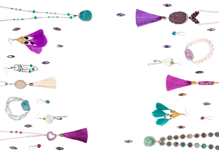 Foto bisutería aislada turquesa y violeta hecha a mano con borlas de gemas y plumas vista superior plana