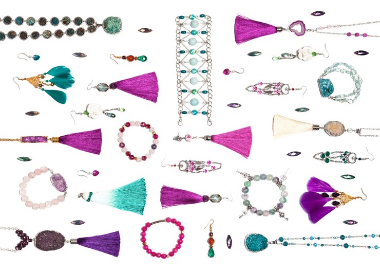 Foto bisutería aislada turquesa y violeta hecha a mano con gemas, borlas y plumas, vista plana superior