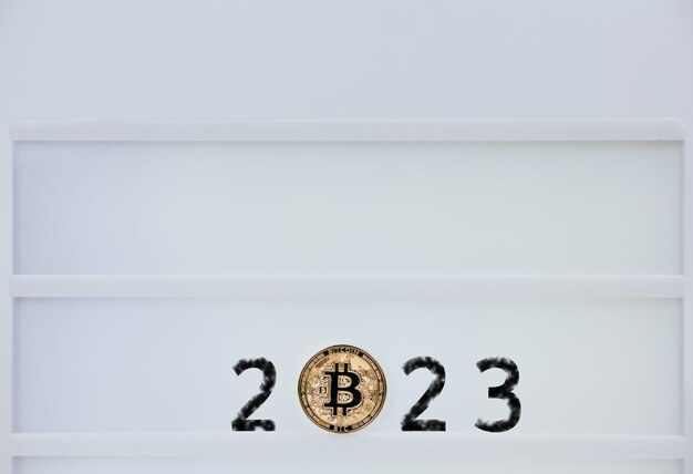 Bitcoin 2023. Los bitcoins están al lado de los números 2. Predicción del precio de bitcoin en el año 2023. Valor futuro de Bitcoin para 2020, 2022, 2030.
