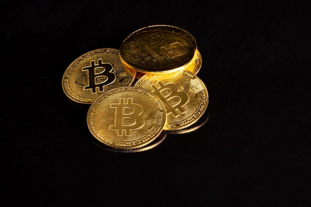Bitcoin-Bitcoin-Münzen auf einem dunklen, reflektierenden Hintergrund, selektiver Fokus