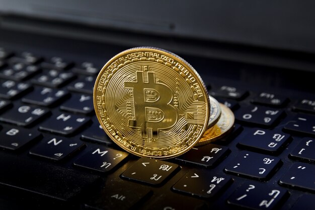 Bitcoin se coloca en el teclado de la computadora portátil, concepto de tecnología de comercio de criptomonedas.