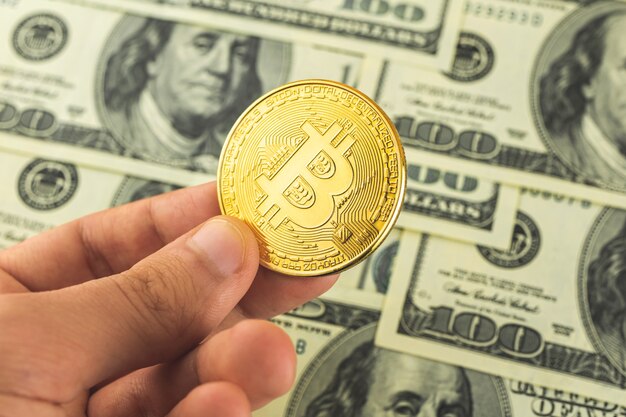 Bitcoin contra dólares americanos, conceito de troca de criptomoeda, foto de plano de negócios com mão e moeda de ouro