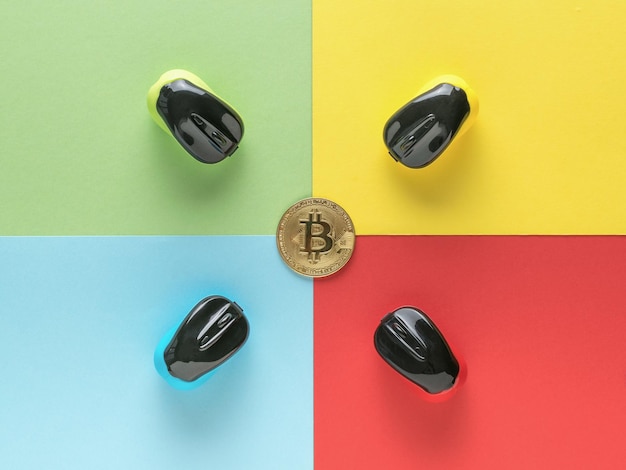 Bitcoin y cuatro ratones de computadora multicolores sobre un fondo de cuatro colores El concepto de minería de criptomonedas Plano