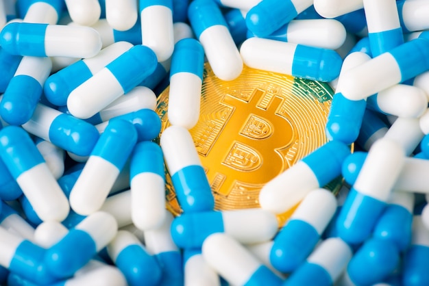 Bitcoin de moeda de ouro afundando em comprimidos médicos. conceito de medicina, tratamento, pagamento de despesas médicas em criptomoeda