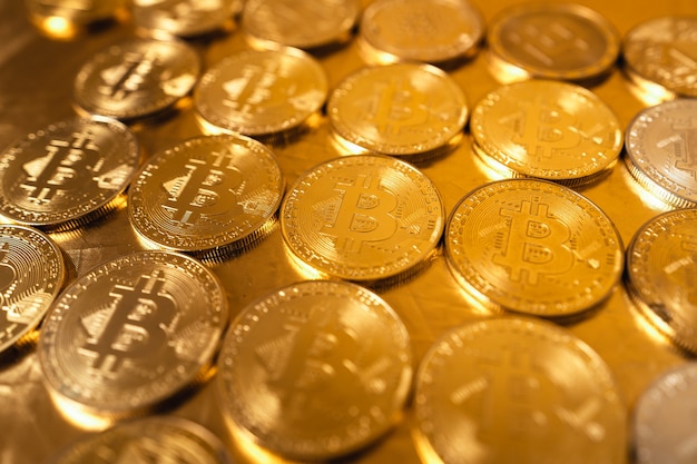 Bitcoin de ouro sobre fundo dourado, moedas de bitcoin empilhadas