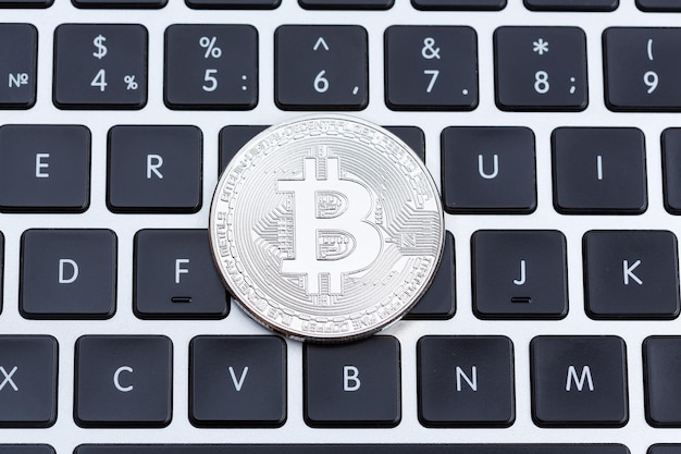 Bitcoin de prata no teclado do computador em close-up Foto de alta resolução