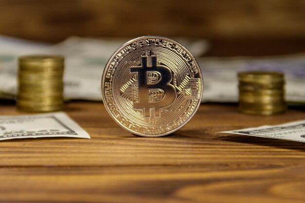 Bitcoin y dólares de plata sobre fondo de madera