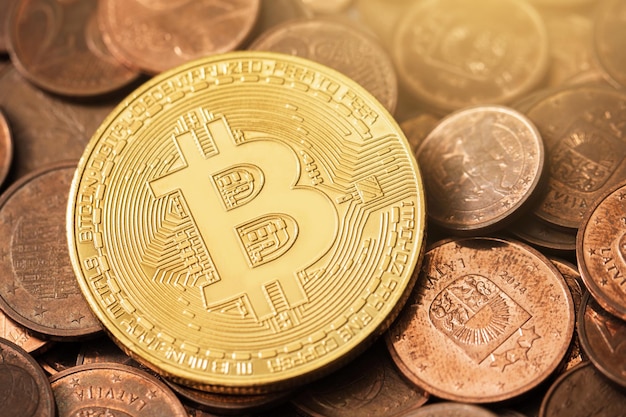 Bitcoin dorado brillante en un montón de monedas de euro de cobre