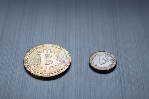 Un bitcoin dorado y una moneda de euro en una criptomoneda de fondo metálico y finanzas comerciales