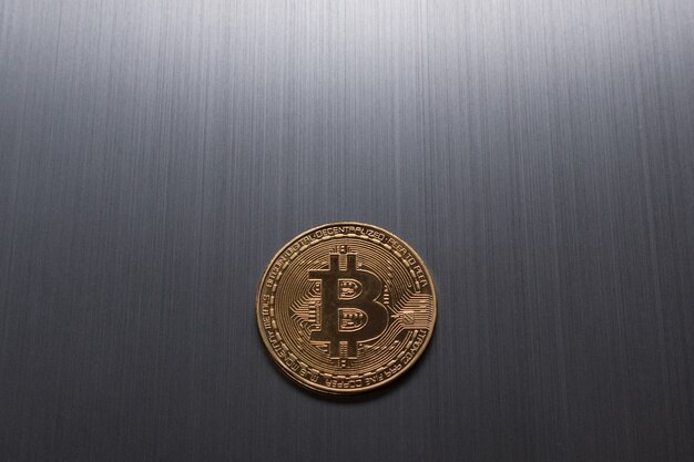 Un bitcoin dorado sobre un fondo metálico