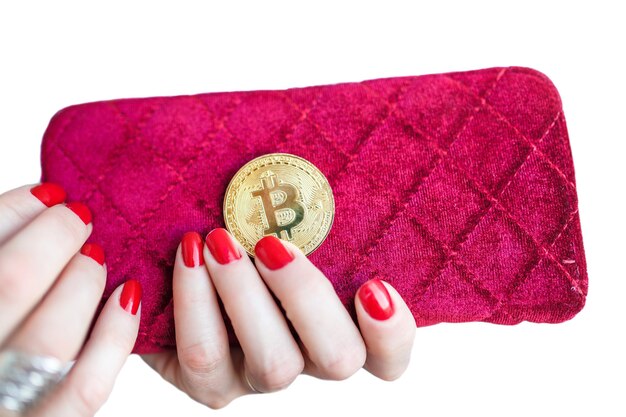 Bitcoin dourado de dinheiro virtual em dedos de bolsa de tecido feminino rosa com unhas vermelhas em uma moeda isolada em fundo branco