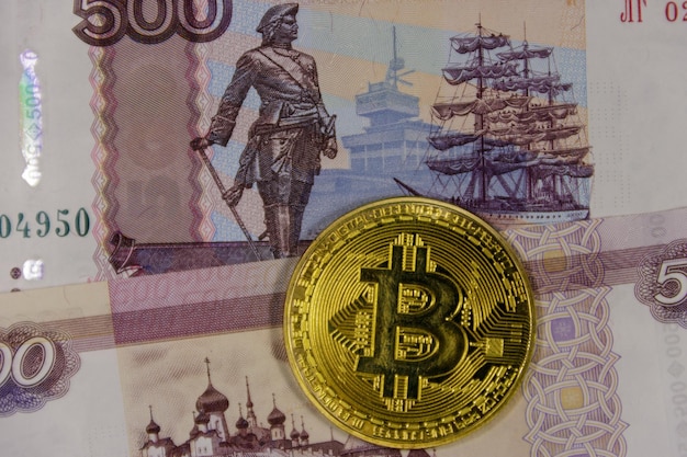 Bitcoin dourado em fundo de notas de quinhentos rublos russos