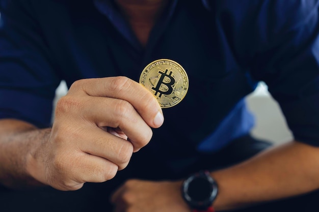 Bitcoin dourado em uma mão de empresário no escritório