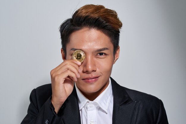 Bitcoin dourado na mão de um homem, símbolo Digitall de uma nova moeda virtual