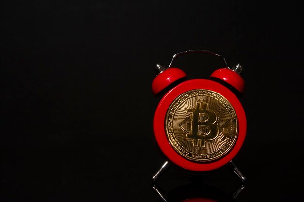 Bitcoin e despertador em fundo preto Conceito de prazo para investir em criptomoeda bitcoin