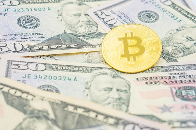 Bitcoin em cima de notas de dólar dos Estados Unidos Bitcoin cash BTC criptomoeda retratada como uma moeda de ouro de ouro sobre dólares dinheiro real dos Estados Unidos 50 dólares bilheteria de cinquenta dólares dos Estados Unidos.