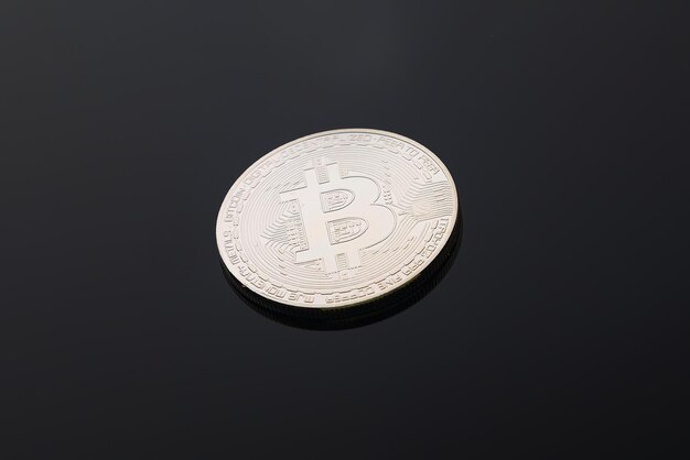 Bitcoin es una criptomoneda de plata sobre un fondo negro.