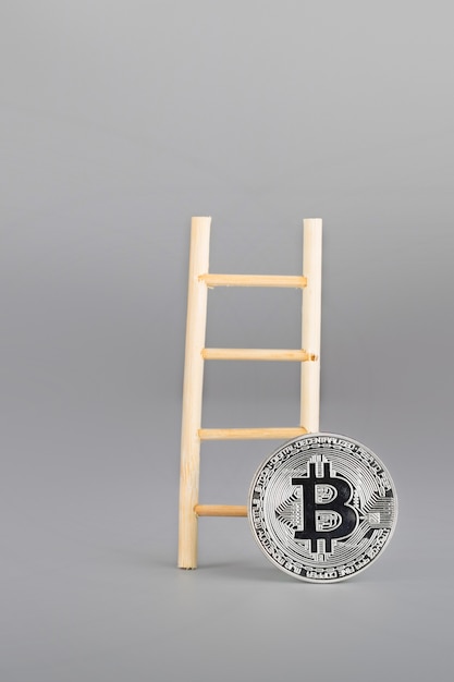 Bitcoin y escalera de madera. De cerca