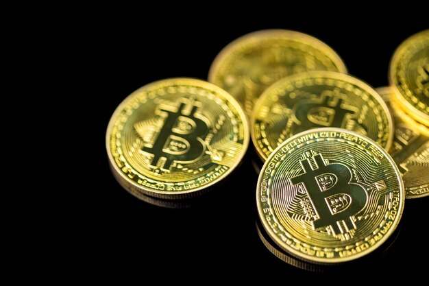Bitcoin en fondo oscuro Cerca el bitcoin dorado una moneda digital opera en un sistema descentralizado con transacciones registradas y nuevas unidades creadas sin autoridad central