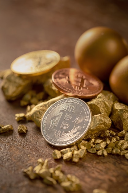 Foto bitcoin gold bitcoin-cryptocurrency físico e grãos de pepita de ouro. conceito de negócios