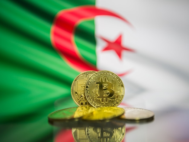 Bitcoin-Goldmünze und defokussierte Flagge von Algerien-Hintergrund. Konzept der virtuellen Kryptowährung.