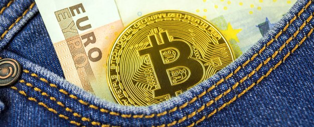 Bitcoin in der Tasche von Blue Jeans gegen das echte Eurogeld, Banner, Kryptowährungsgeschäft und Finanzkonzepthintergrundnahaufnahme, goldene Münze