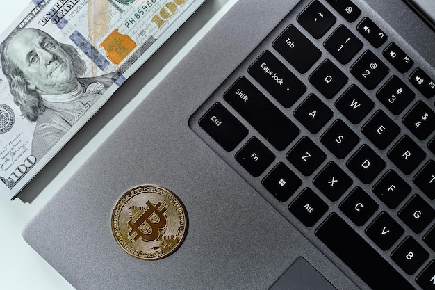 Bitcoin monedas de oro dólares estadounidenses teclado de computadora portátil de cerca