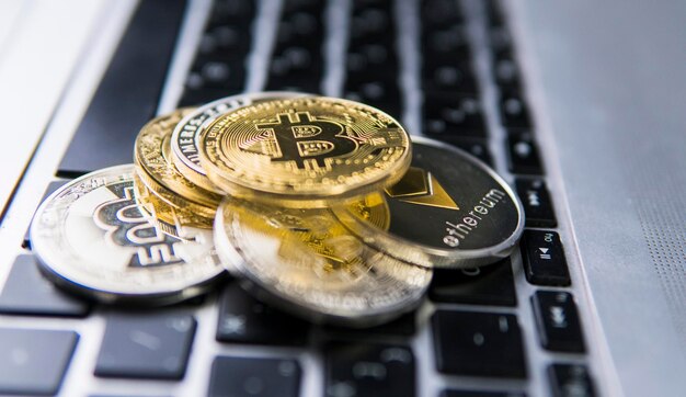 Bitcoin-Münze auf anderen Krypto-Münzen auf einer Tastatur von Laptop-Bitcoin-Goldmünzen