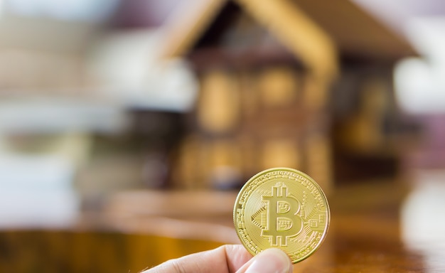 Foto bitcoin-münze in der hand. kauf und verkauf von immobilien mit bitcoin