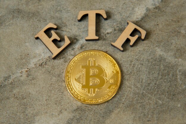 Bitcoin-Münze mit ETF-Text auf Steinhintergrund, Konzept, das den digitalen Geldfonds betritt. ETF- und Bitcoin-Kryptowährungskonzept