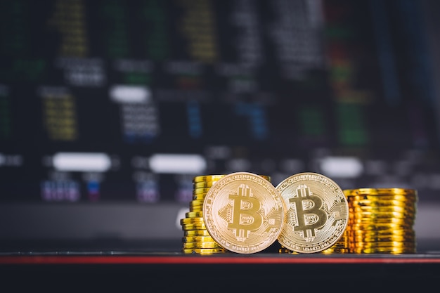 Bitcoin-Münzen stapeln und zwei Bitmünzen in der Front mit Digital-backgro des Aktienindex-Diagrammdiagramms