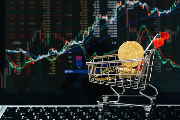 Bitcoin de oro en un pequeño carrito de compras con gráfico de acciones para el fondo, Invertir con activos digitales, Finanzas futuras, blockchain. Concepto de mercado de valores, dinero digital y negocios bursátiles.