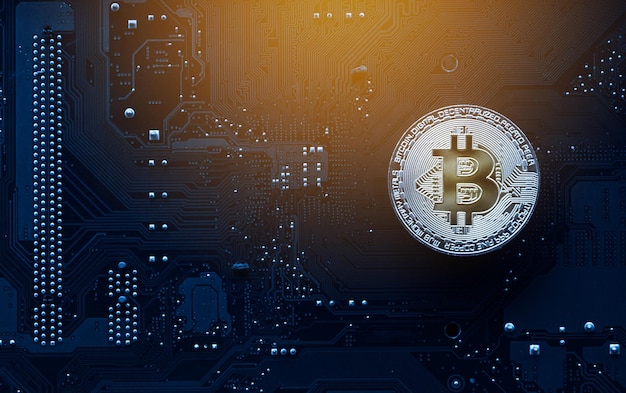 Bitcoin de oro en la placa base de la computadora con gráfico comercial Concepto de minería y comercio de bitcoin