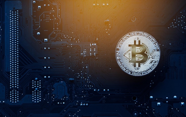 Bitcoin de oro en la placa base de la computadora con gráfico comercial Concepto de minería y comercio de bitcoin