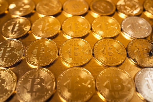 Bitcoin de oro sobre fondo de oro, monedas bitcoin apiladas