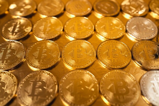 Bitcoin de oro sobre fondo de oro, monedas bitcoin apiladas