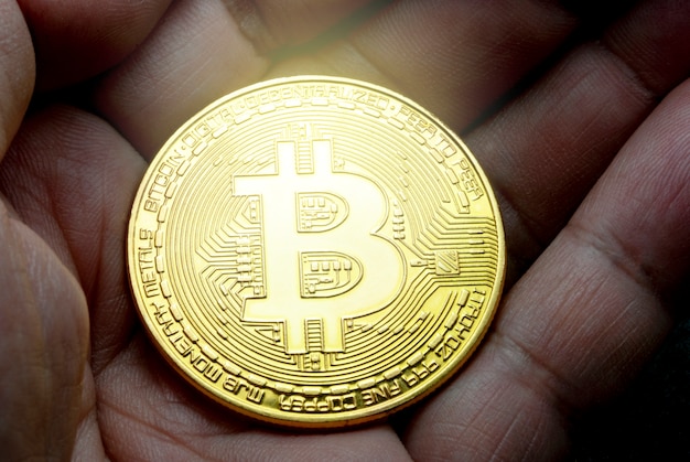 Bitcoin ouro na mão com fundo preto padrão turva
