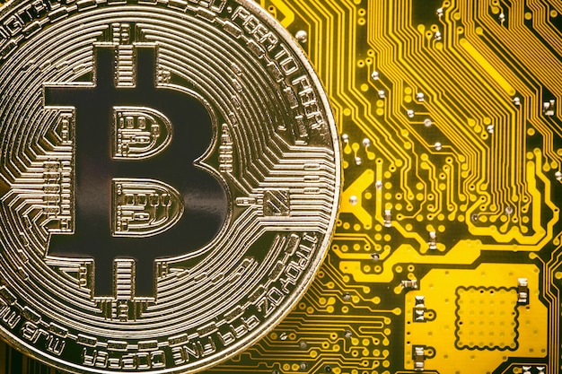 Bitcoin en la placa base amarilla del circuito de la computadora de cerca.