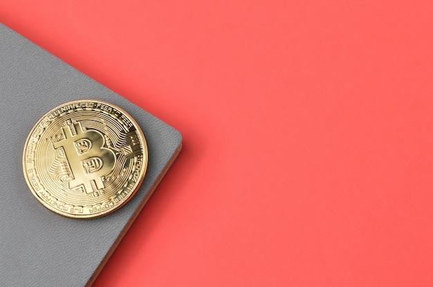 Bitcoin y portátil sobre fondo rojo con espacio de copia