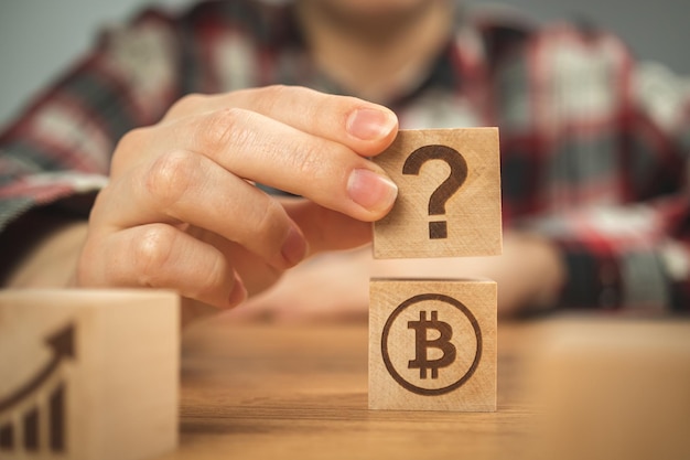 Bitcoin y símbolos de interrogación en cubos de madera Concepto de ideas de preguntas frecuentes sobre planes de inversión y negocios