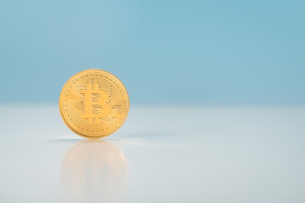 Bitcoin steht vor blauem Hintergrund goldene Bitcoin-Münzen auf einer reflektierten Oberfläche des Tisches Virtuelles Kryptowährungskonzept Mining von Bitcoins Online-Geschäft Bitcoins-Handel