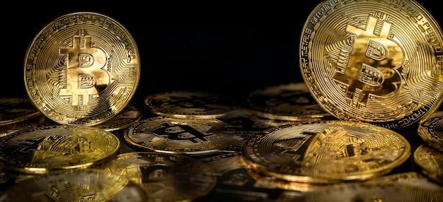 Bitcoin-Technologie-Banner-Hintergrund. Nahaufnahme goldene Bitcoins auf dunklem Hintergrund mit Kopienraum, Kryptowährungs-Investitionskonzept. Finanzhintergrund der digitalen zukünftigen Münzwährung.