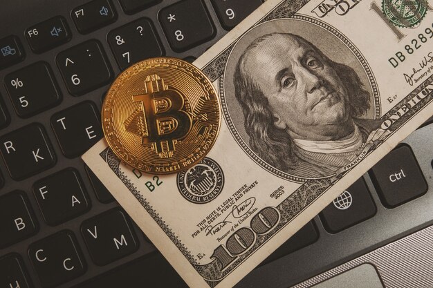 Bitcoin en un teclado de computadora y $ 100