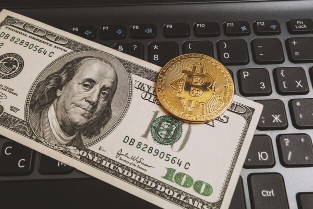 Bitcoin en un teclado de computadora y $ 100