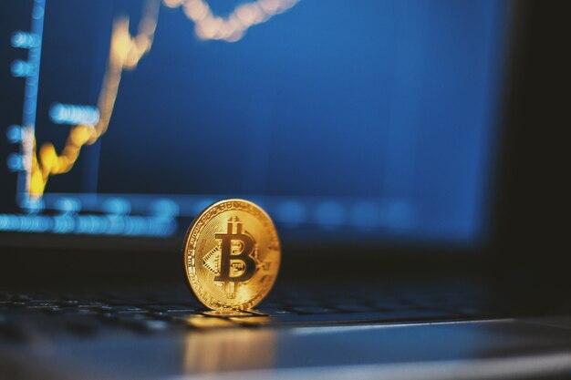 Bitcoin en teclado de computadora y gráfico de crecimiento