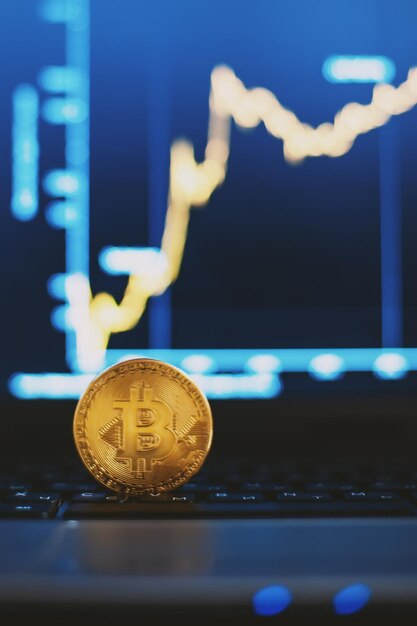 Bitcoin en el teclado de la computadora y la tabla de crecimiento